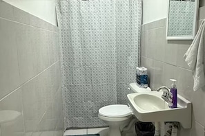 Ein Badezimmer mit Toilette, Waschbecken und Duschvorhang.