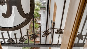 A wrought iron gate with floral designs, leading to a courtyard with outdoor furniture. - Hotel Granada Embassy (Cali)
