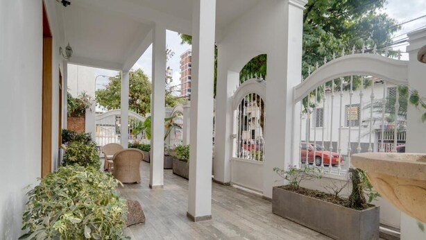 A covered outdoor area with columns, planters, and a view of the street. - Hotel Granada Embassy (Cali)