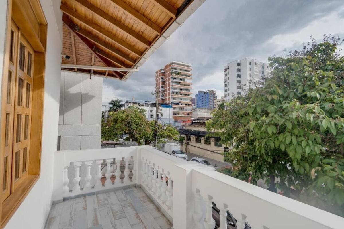 Un balcón con vistas a edificios y árboles circundantes.
