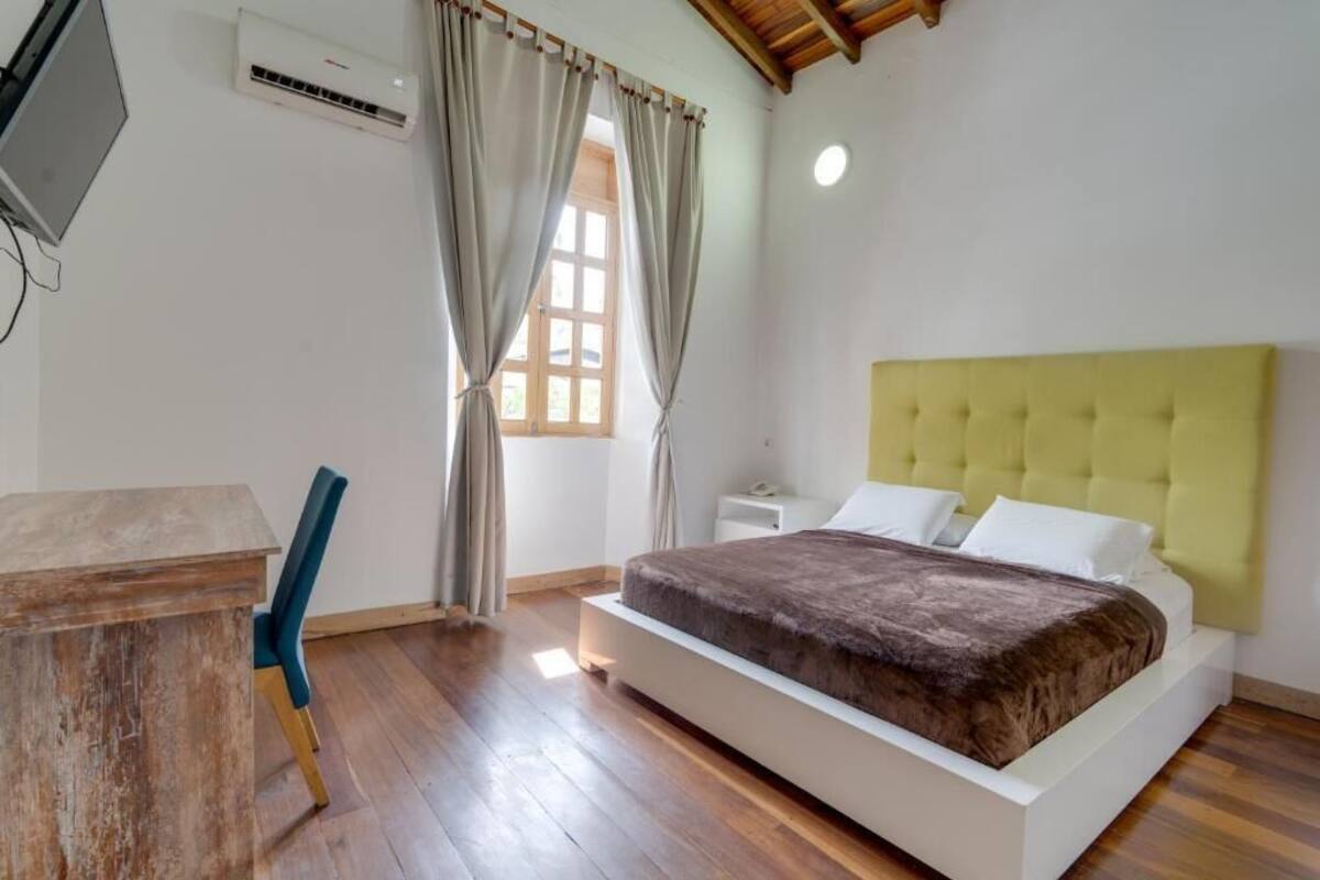 Un dormitorio con una cama, un escritorio y una silla.