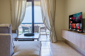 Apartment, Balkon, Stadtblick | Wohnbereich | 65-Zoll-Smart-TV mit Digitalempfang