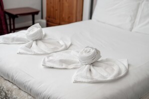 A bed with white linens and two towels arranged in a bow shape on the bed. - Charming Spacious Guesthouse, Edinburgh - Pass the Keys (Edinburgh)