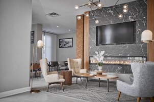 Una sala de estar moderna con chimenea, televisor de pantalla plana y comedor.