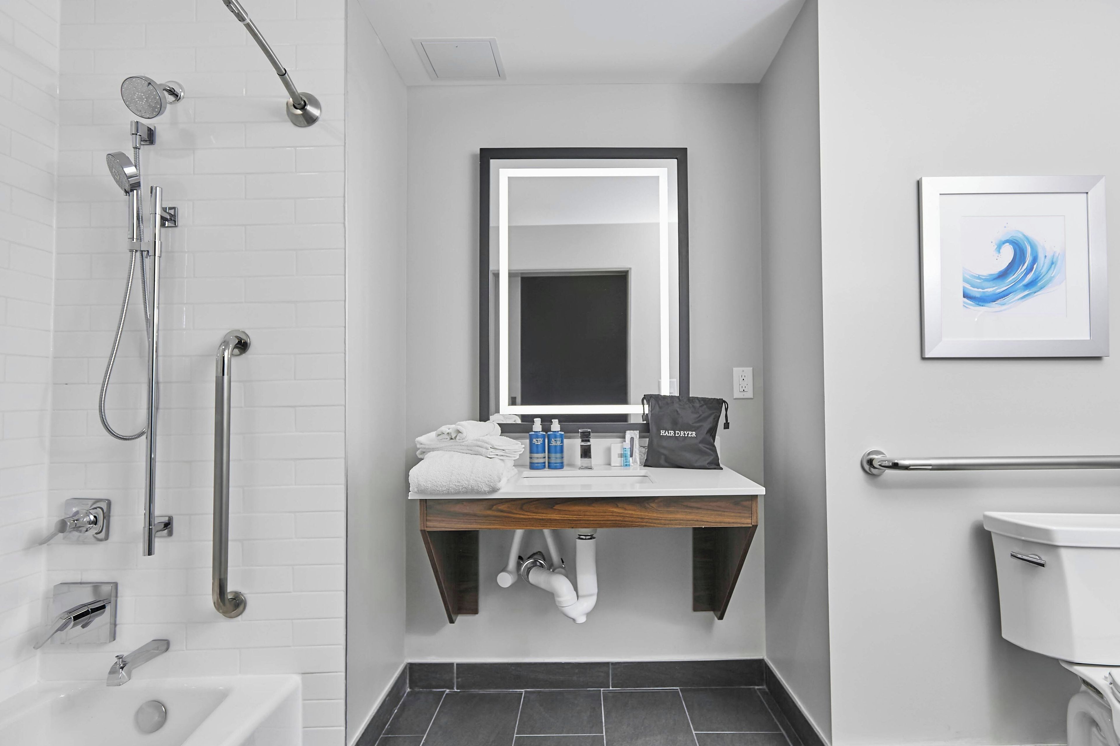 A modern bathroom with a shower, toilet, and sink.
