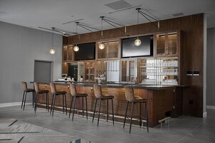 Una cocina moderna con barra, armarios de madera y televisor de pantalla plana.