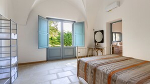 A bedroom with a large window, a bed, a wardrobe, and a mirror. - Casa Agata by BarbarHouse (Ruffano)