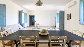 A dining area with a table, chairs, a hanging light fixture, and a bowl on the table. - Casa Agata by BarbarHouse (Ruffano)