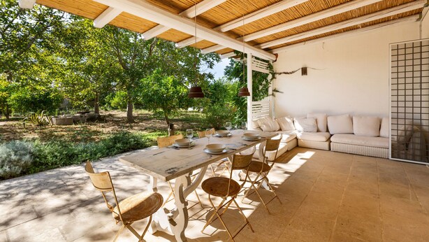 An outdoor patio with a wooden table, chairs, and a sofa. - Casa Agata by BarbarHouse (Ruffano)