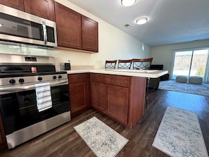 A modern kitchen with stainless steel appliances, wooden cabinets, and a large island.