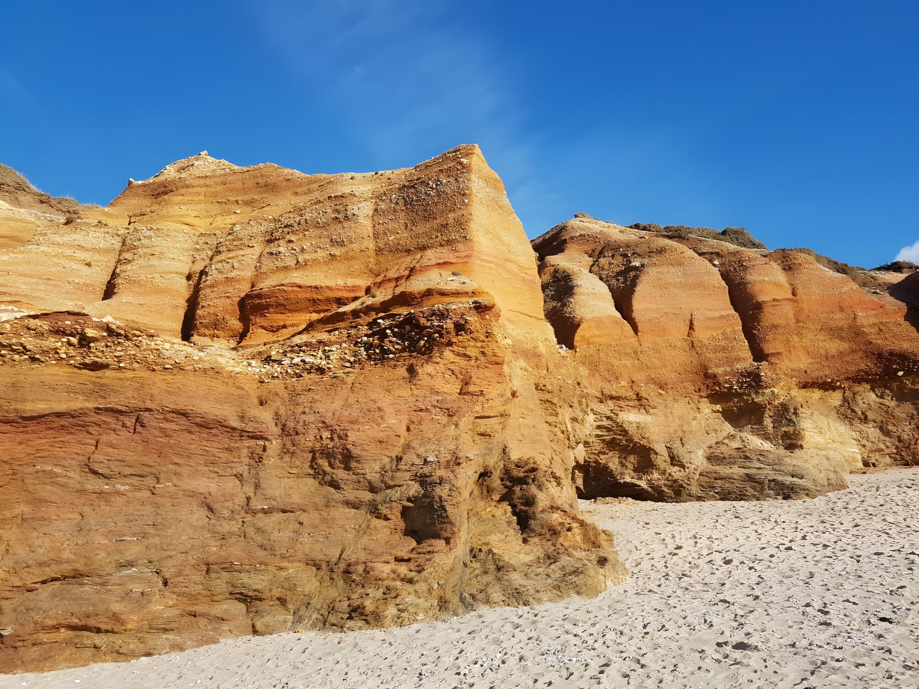 A rocky landscape with layered sedimentary rock formations.