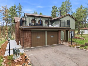 A two-story house with a balcony, a garage, and a statue in the driveway. - Spacious Colorado Retreat, Game Room, Solarium, Patios & Mountain View’s (Evergreen)