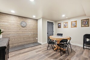 A room with a wooden wall, a dartboard, a door, and framed pictures on the wall. - Spacious Colorado Retreat, Game Room, Solarium, Patios & Mountain View’s (Evergreen)