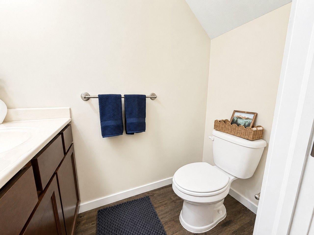 Une salle de bain équipée de toilettes, d’un lavabo et d’un porte-serviettes avec deux serviettes.