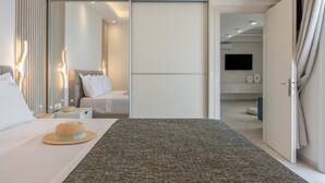 Una habitación de hotel moderna con una cama, un espejo, un televisor y un equipo de aire acondicionado.