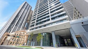 A modern building with a curved entrance, large windows, and a prominent entrance area. - 2408 New Luxury Downtown Retreat, Gym, & Prime Location 1B1B (Miami)