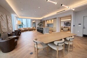 A modern hotel lobby with a large wooden conference table, comfortable seating, and a view of the city. - 2408 New Luxury Downtown Retreat, Gym, & Prime Location 1B1B (Miami)