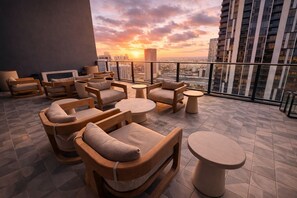 A rooftop lounge with outdoor seating and a cityscape view at sunset. - 2408 New Luxury Downtown Retreat, Gym, & Prime Location 1B1B (Miami)