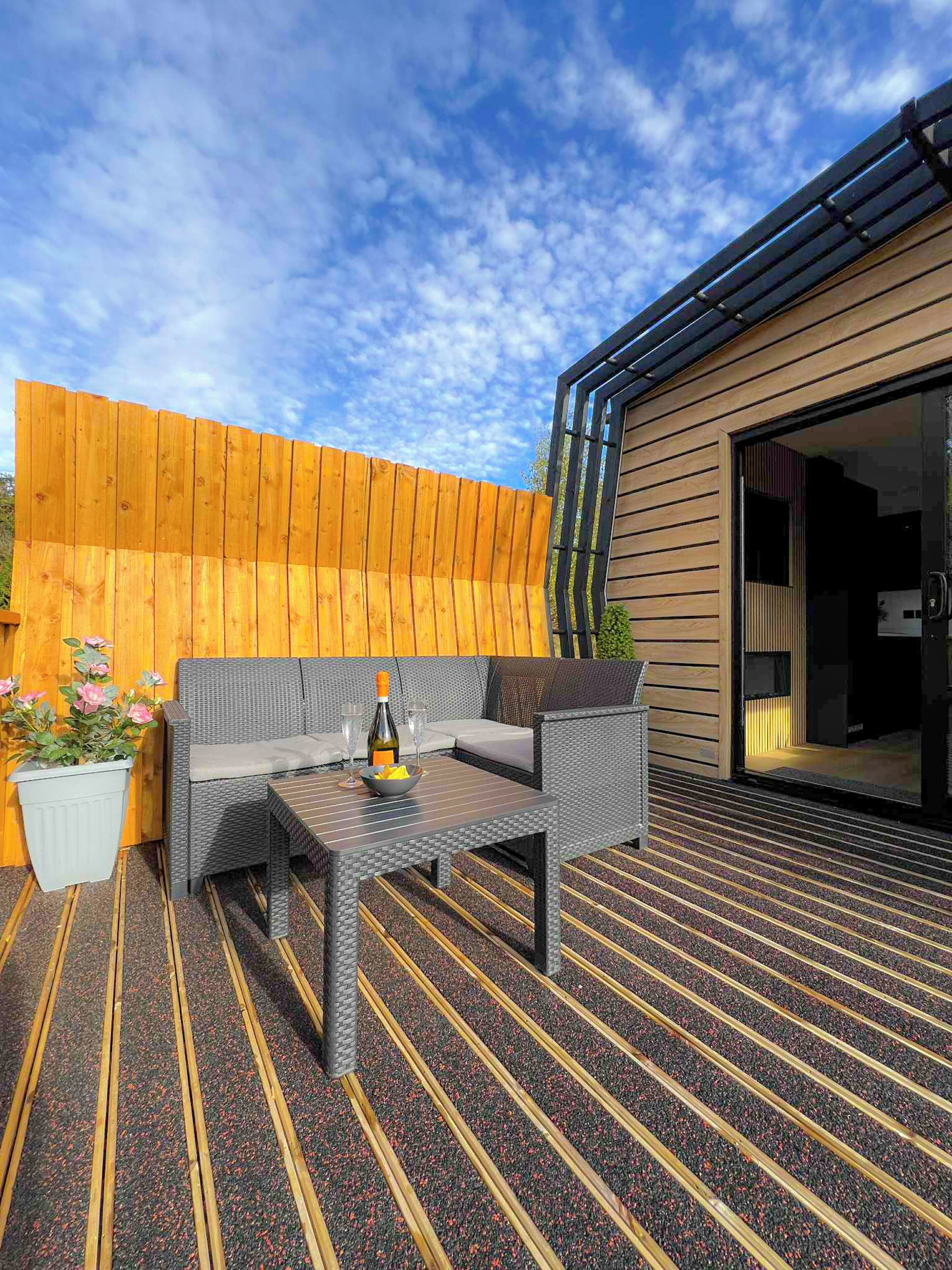 An outdoor seating area with a table, chairs, and a potted plant.