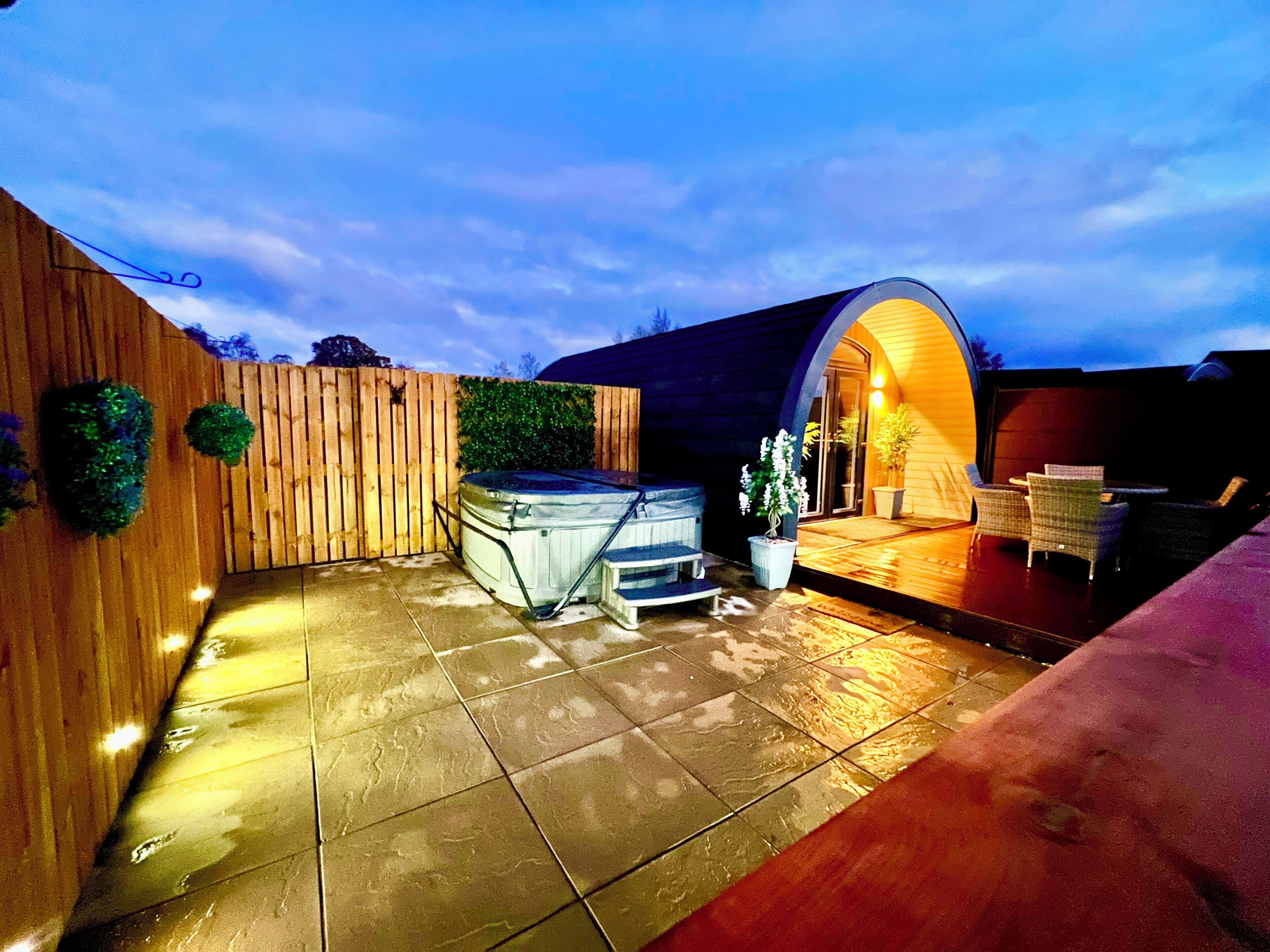 Un jacuzzi, mobiliario exterior y un porche cubierto.