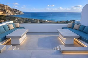 A modern outdoor seating area with a view of the sea and a rocky landscape. - Villa 'Aqua Blue 2' with Private Pool and Sea View (Amoopi)