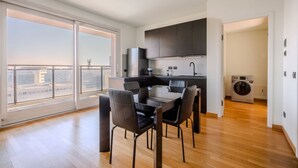 Una cocina moderna con zona de comedor, ventanas amplias y lavadora.
