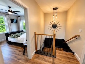 A bedroom with a bed, a ceiling fan, a TV, and a view of greenery outside. - Spacious 4-bedroom house in quiet Wilmington (Wilmington)