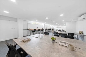 A modern conference room with a long table, multiple chairs, and a small plant on the table. - Modern 2-Bed Gravesend Apt with Games Room (Gravesend)