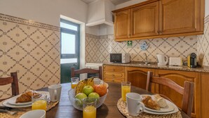 A breakfast setting with a table, chairs, a bowl of fruit, croissants, and juice glasses. - #361 Quinta Brito Lima D (Paderne)