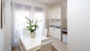 A modern kitchen with white cabinets and a built-in sink. - Hotel Princ (Budva)