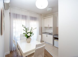 A modern kitchen with white cabinets and a built-in sink. - Hotel Princ (Budva)