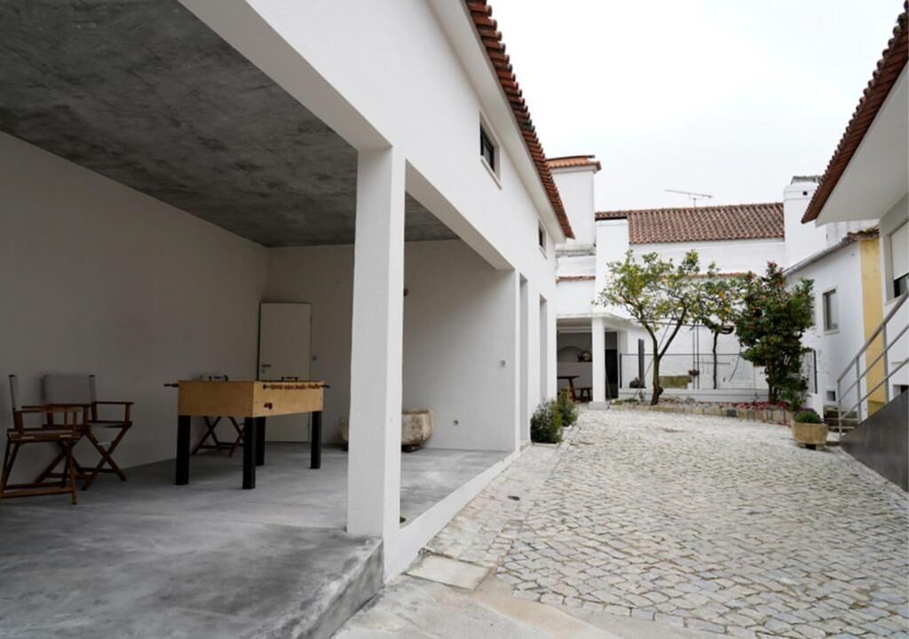 A courtyard with a foosball table, a chair, and a door.