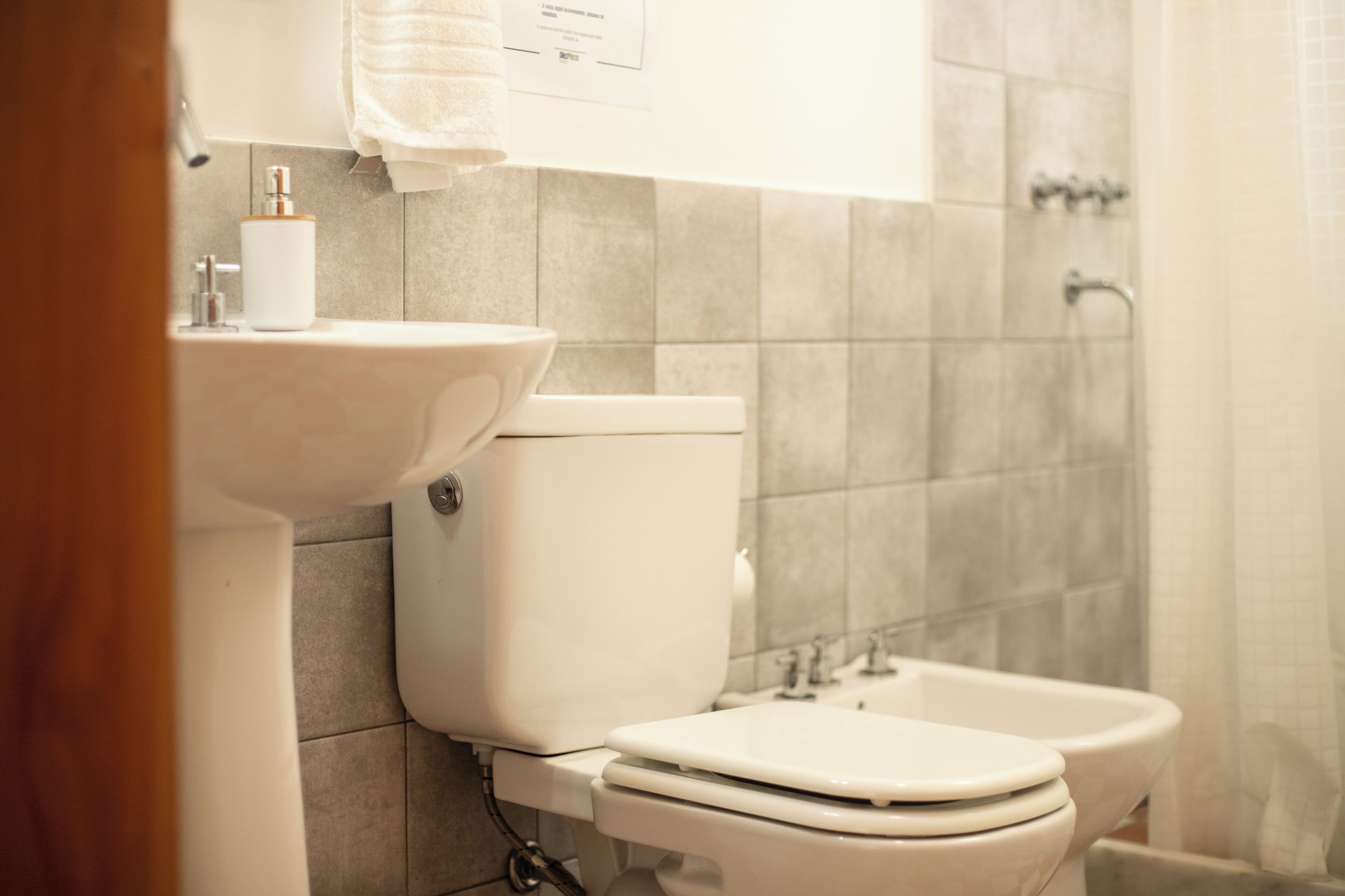 A bathroom with a toilet, bidet, and sink.