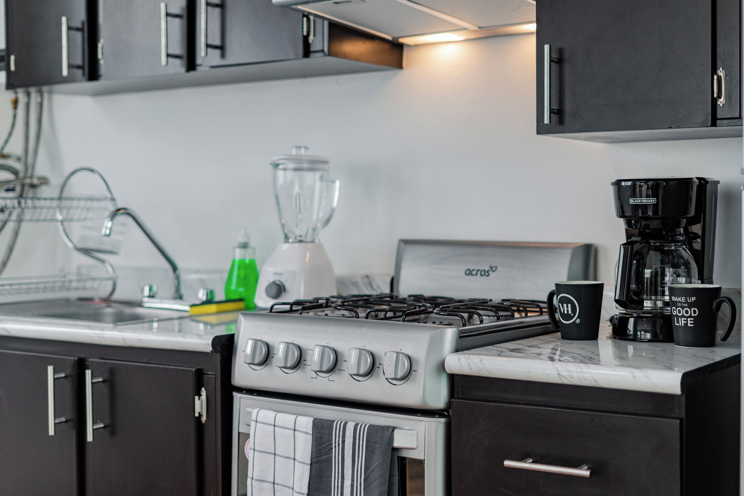 A kitchen with a stove, oven, coffee maker, and a blender.