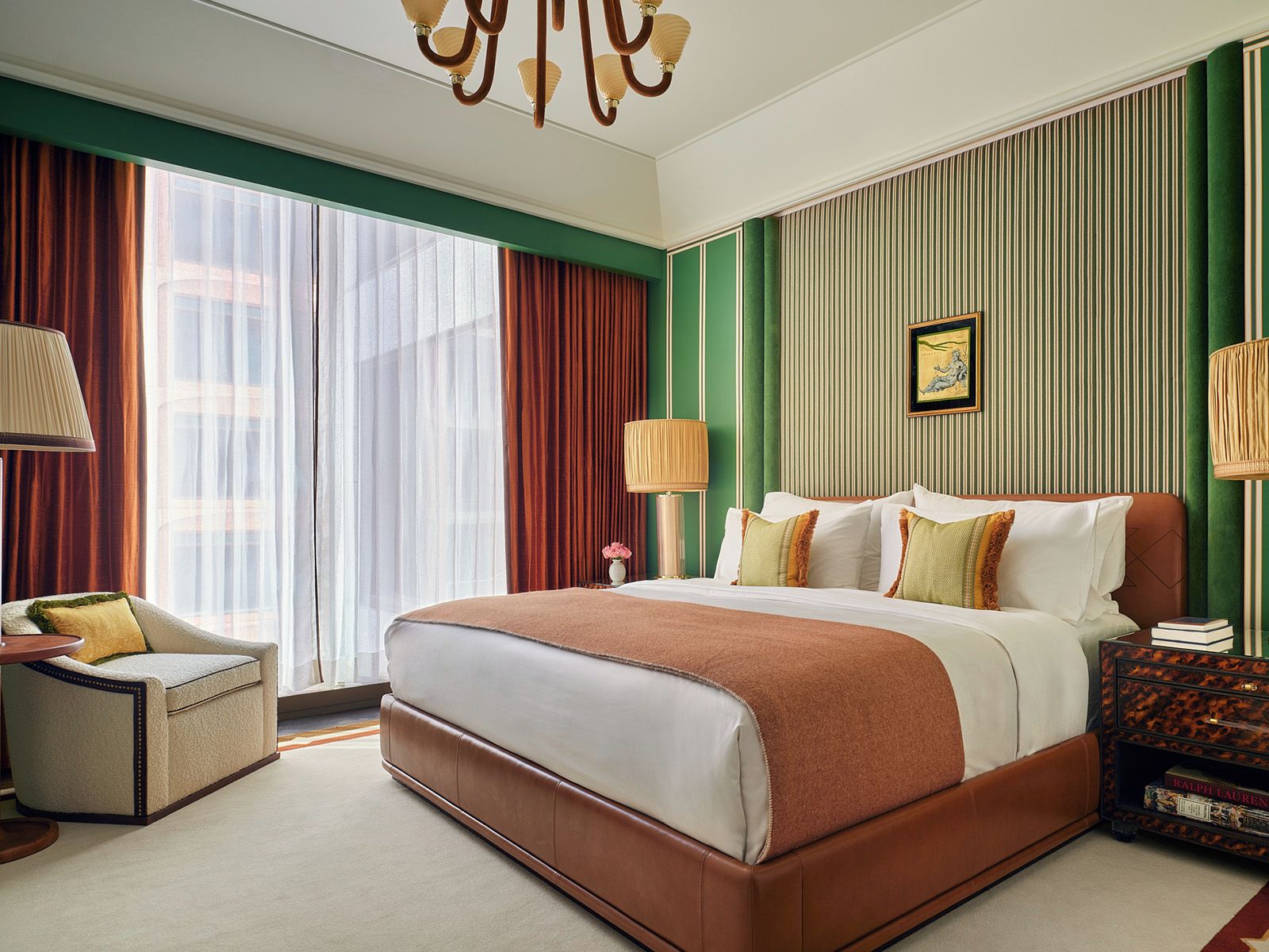 Une chambre d’hôtel avec un grand lit, une chaise, une table de chevet et une fenêtre avec des rideaux.