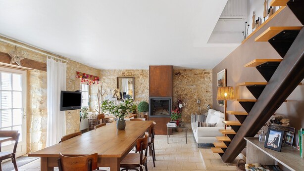 A dining area with a wooden table and chairs, a fireplace, and a staircase with shelves. - Guest Room “Aubergine” with Shared Pool, Near Sarlat (Proissans)
