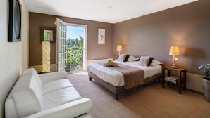 A bedroom with a bed, bedside tables, a chair, and a view through a glass door. - Guest Room 'Chambre Taupe' with Shared Pool, Near Sarlat (Proissans)