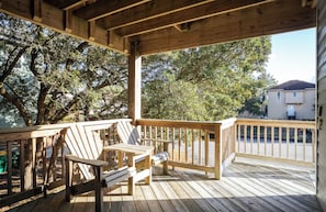 A wooden deck with a railing, a bench, and a chair. - Blue Heron House! Pool, Hot tub! Close to Beach! (Corolla)