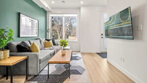 Ein modernes Wohnzimmer mit einer Couch, einem Couchtisch und Kunstwerken an den Wänden.