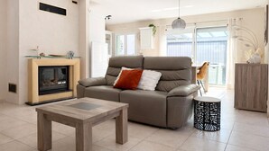 Ein modernes Wohnzimmer mit Kamin, Sofa, Couchtisch und Dekorationselementen.