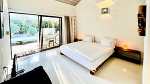A bedroom with a large bed, a sliding glass door to a patio, and a wall-mounted light fixture. - Spacious Jungle Villa nr Tamarindo w big pool - Perfect for Retreats (Tamarindo)