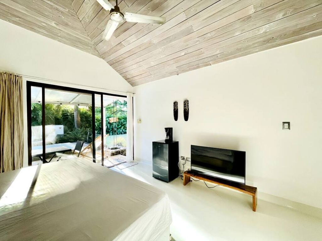 A modern bedroom with a bed, a TV, and a coffee machine.