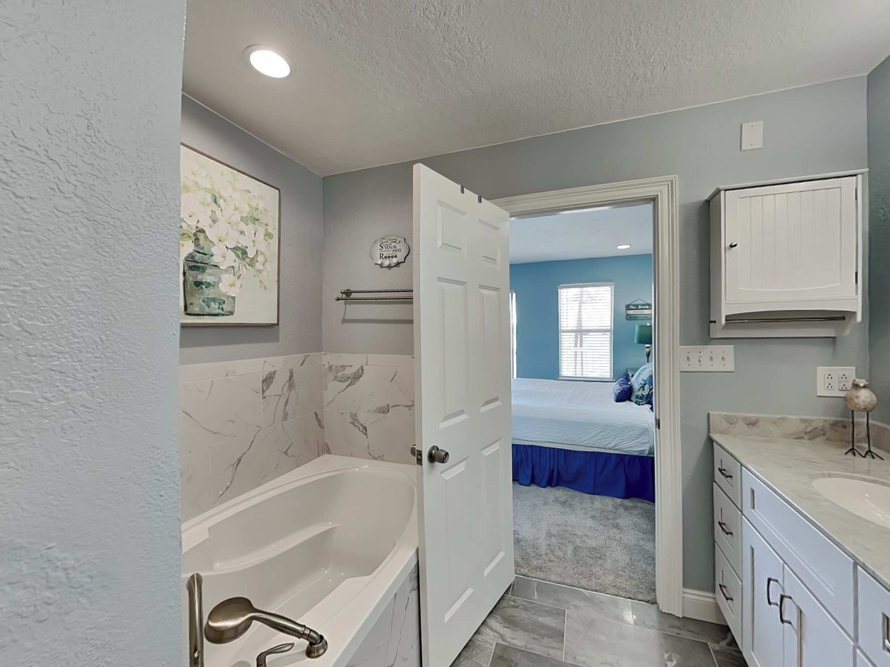 A bathroom with a bathtub, a sink, and a mirror.
