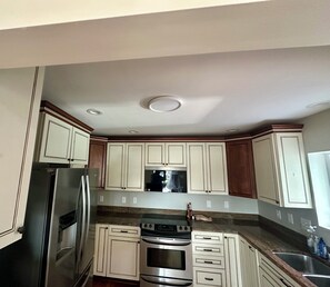 A kitchen with white cabinets, stainless steel appliances, and a granite countertop. - Somerset On The Magothy, an exceptional waterfront property in Greater Annapolis (Severna Park)