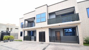 A modern two-story building with a flat roof, large windows, and a balcony. - A cosy and well presented 2 bedroom apartment (JXR2+94H, Sakumono)