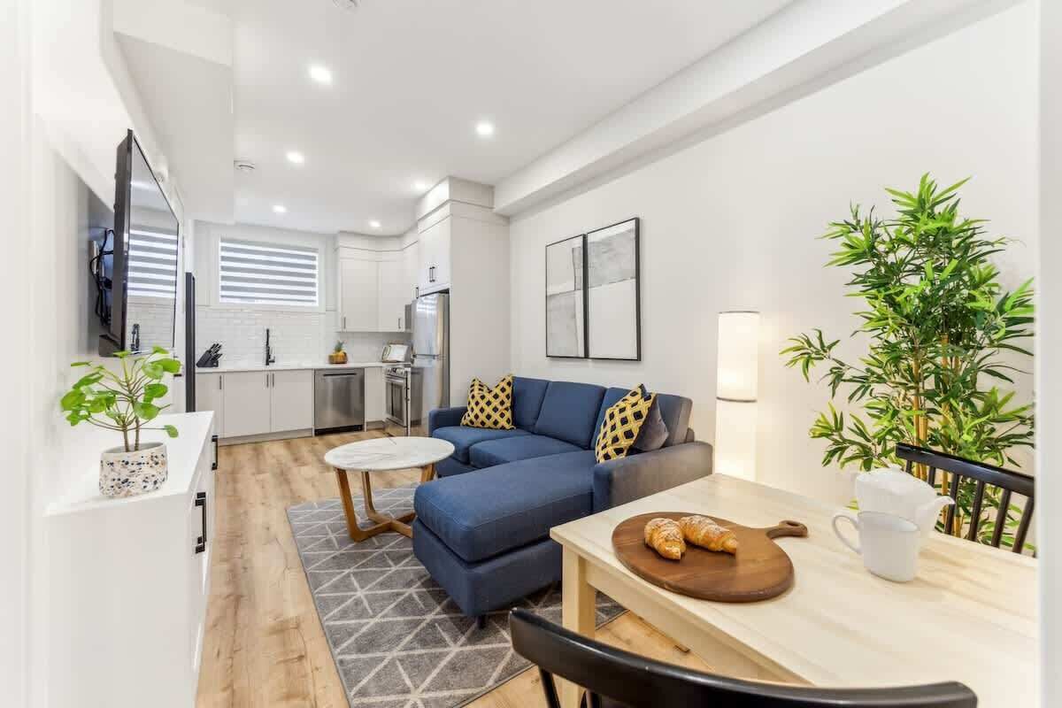 A modern living space with a sofa, dining table, and kitchen area.
