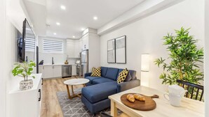 Ein moderner Wohnraum mit Sofa, Esstisch und Küchenzeile.
