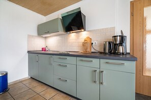 Une cuisine au design moderne, équipée d’une cuisinière intégrée, d’une machine à café et d’un grille-pain.