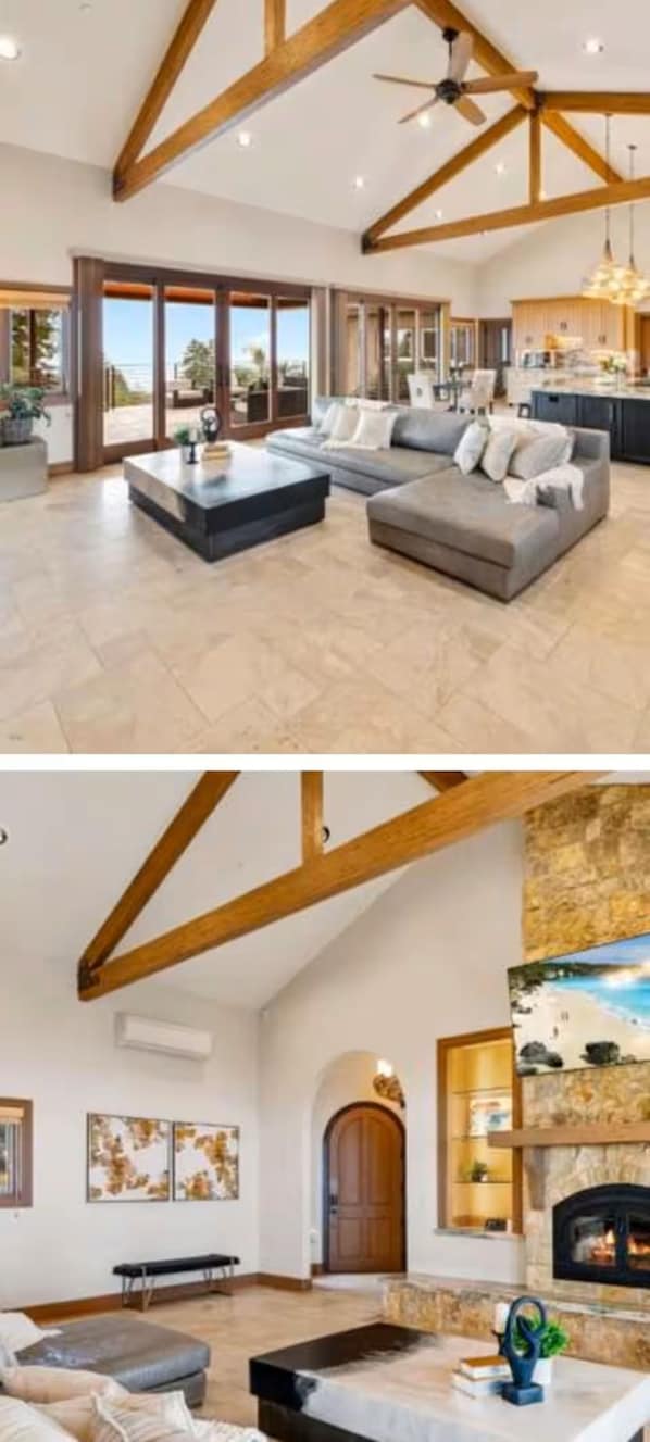 A spacious living area with a large sofa, a coffee table, and a fireplace.