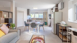 A modern apartment with a dining area, kitchen, and living room.